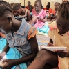 Pigerne fra en skole i Mahad arbejder koncentreret. Der er ingen møbler, så de sidder på gulvet. Foto: Irene Frederiksson